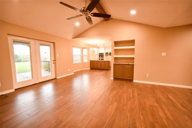 a view of a kitchen with wooden floor and a window
