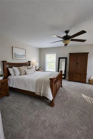 a spacious bedroom with a bed and a ceiling fan