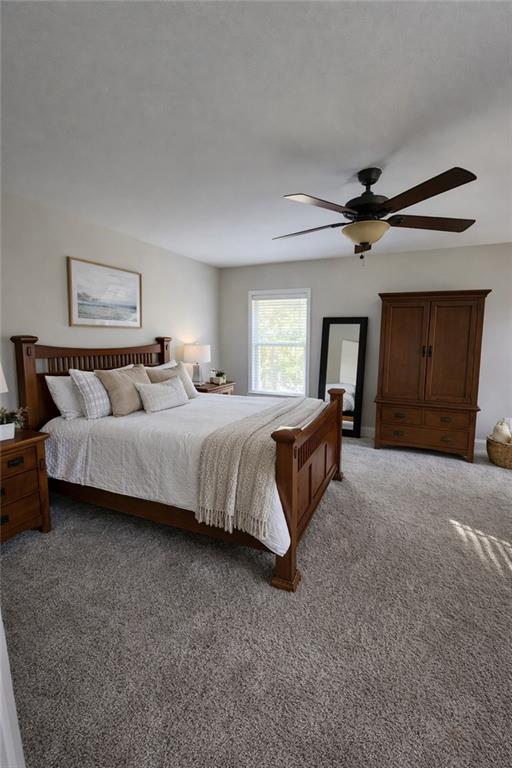 249 Serenity Loop Cataula, GA 31804 - Photo 15 of 16 a spacious bedroom with a bed and a ceiling fan