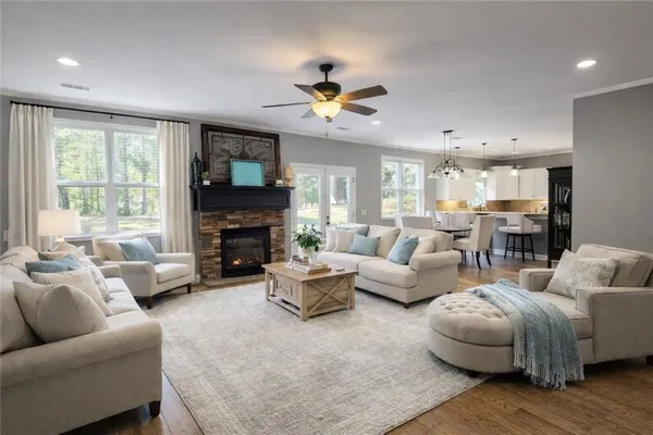 a living room with furniture a fireplace and a large window