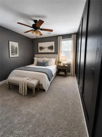 a bedroom with a bed couch and a large window