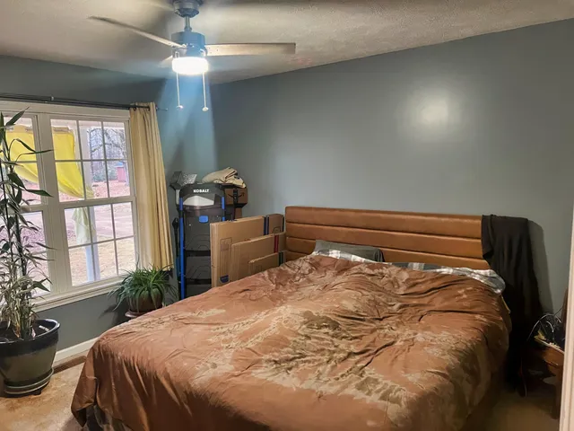 a living room with furniture a bookshelf and a window