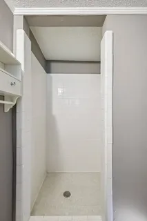 an empty room with a chandelier fan and windows