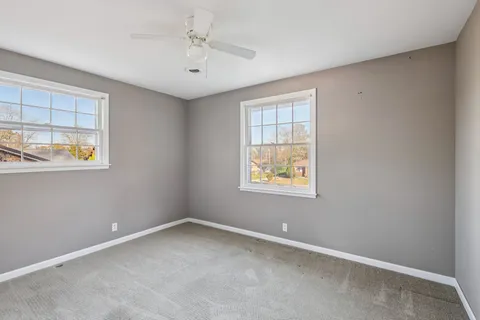 an empty room with windows and closet