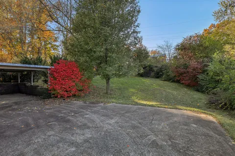 a view of a chair and table in backyard of the house