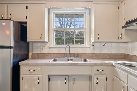 a kitchen with stainless steel appliances cabinets a window and a sink