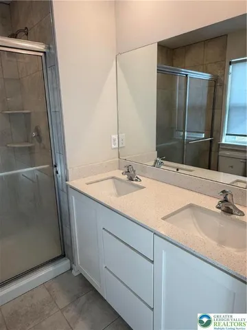 a bathroom with a double vanity sink and a mirror