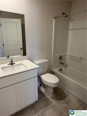 a bathroom with a granite countertop toilet a sink and a bathtub