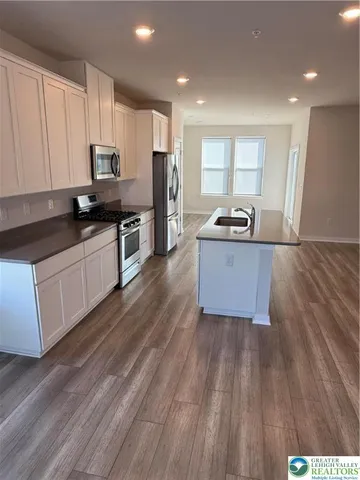 a kitchen with granite countertop a sink and steel appliances