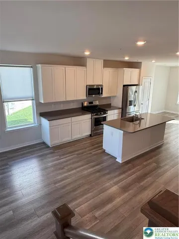 a kitchen with stainless steel appliances kitchen island granite countertop a stove a sink and a refrigerator