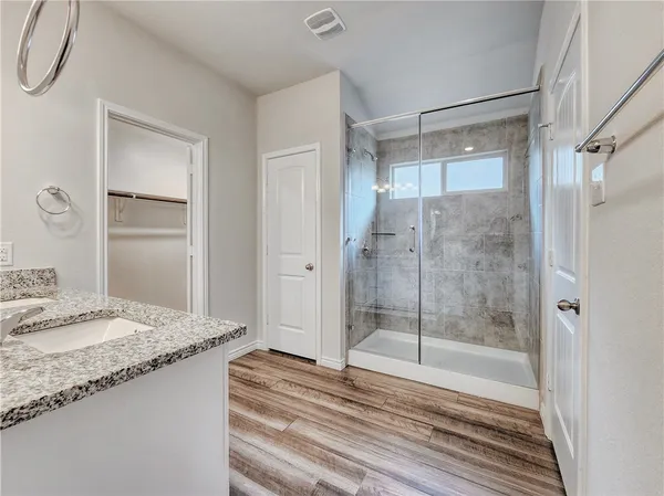 a bathroom with a granite countertop sink and shower