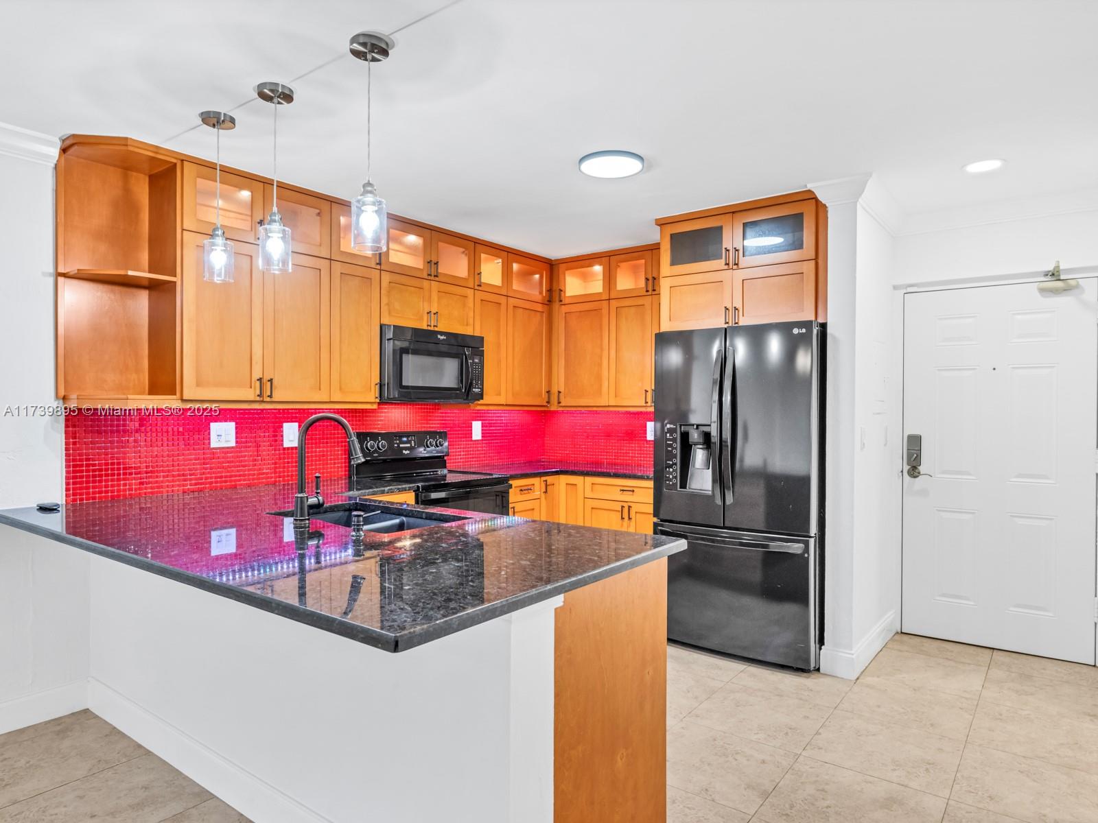 a kitchen with stainless steel appliances granite countertop a refrigerator and a sink