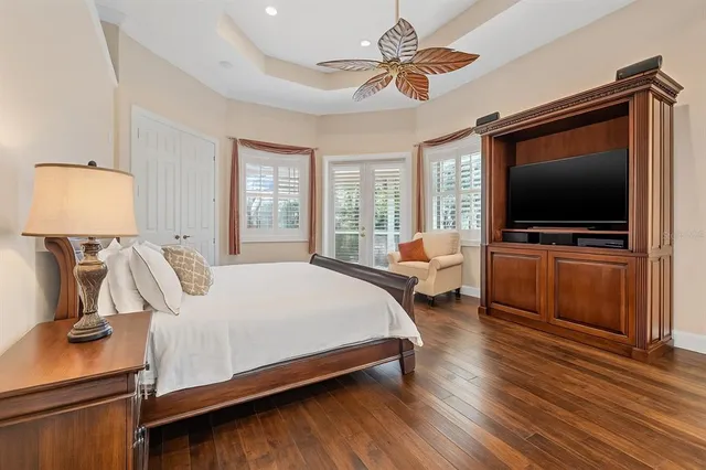 a bedroom with bed tv and window