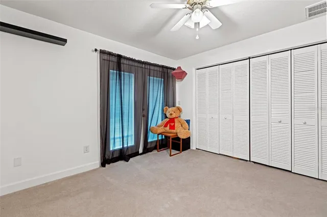 an empty room with closet and a chandelier fan