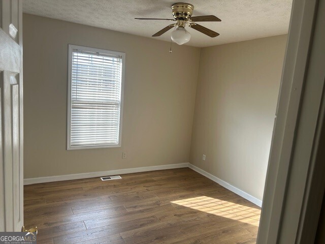 341 Baker Street Monroe, GA 30655 - Photo 9 of 10 an empty room with wooden floor fan and windows