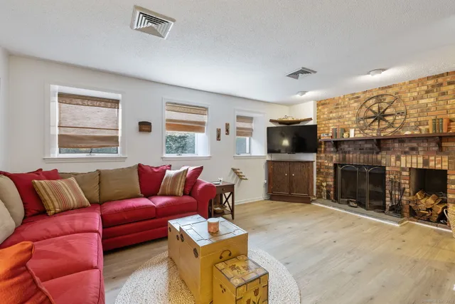 a living room with furniture a flat screen tv and a fireplace