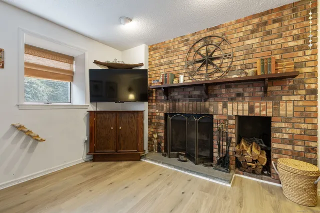 a view of an empty room with fire place and a fireplace