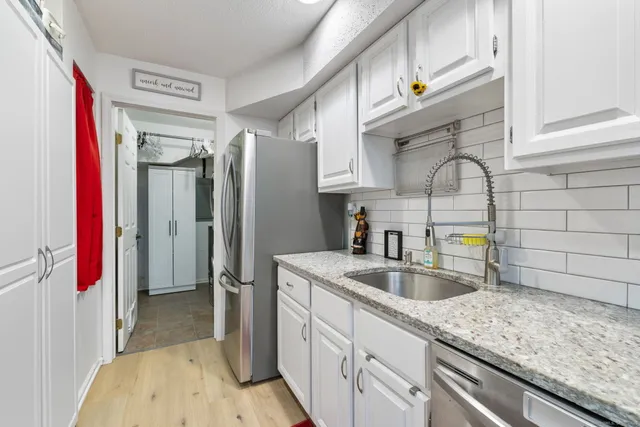 a kitchen with stainless steel appliances granite countertop a sink and refrigerator