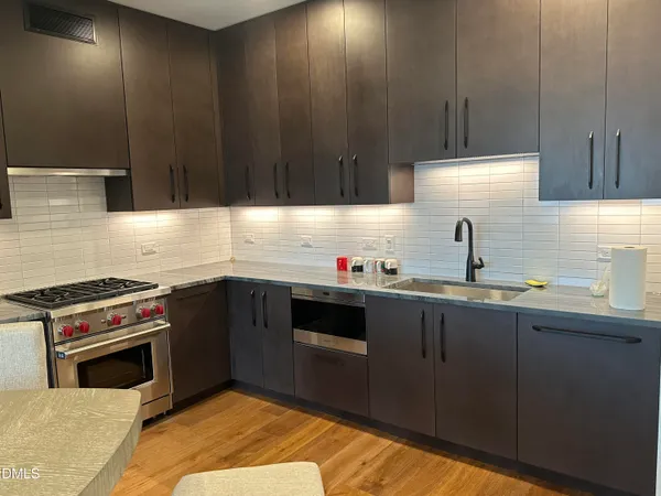 a kitchen with a sink stove top oven and cabinets