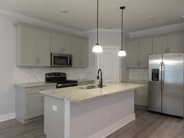 a kitchen with a sink a counter space appliances and cabinets