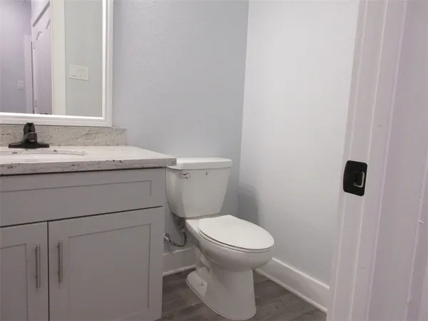 a bathroom with a granite countertop toilet and a sink