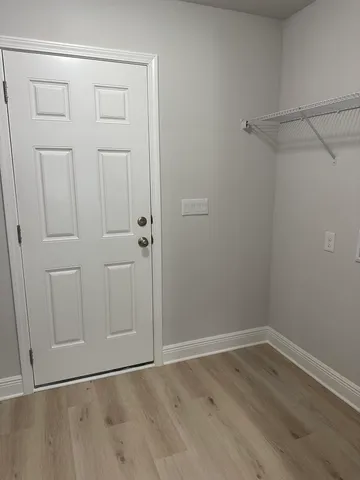 an empty room with windows and ceiling fan