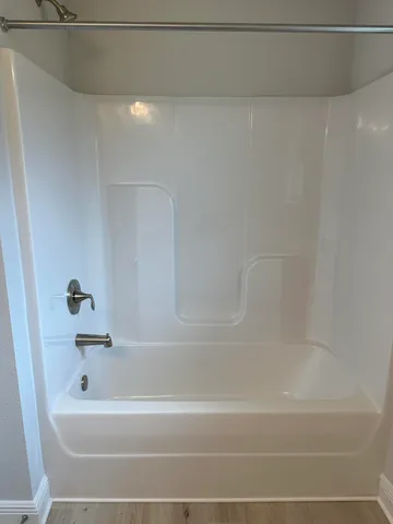 a view of kitchen with stainless steel appliances wooden floor and living room view