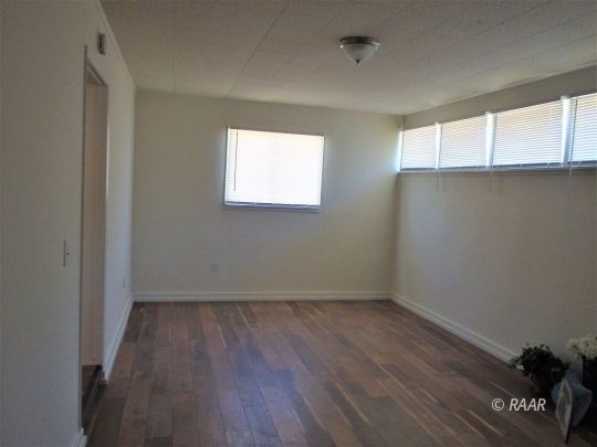 437 North Fairview Street Ridgecrest, CA 93555 - Photo 18 of 35 an empty room with wooden floor and windows
