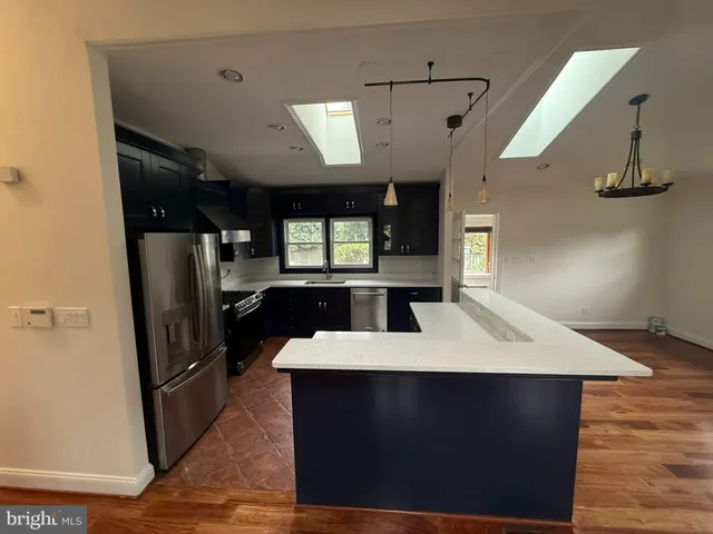 a large kitchen with stainless steel appliances granite countertop a refrigerator a sink a stove and island