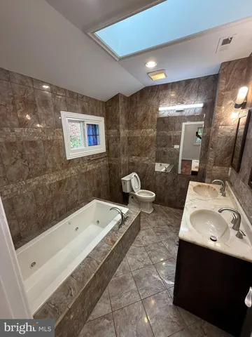 a bathroom with a tub sink and mirror