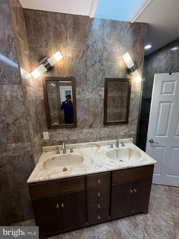 a bathroom with a double vanity sink and a mirror