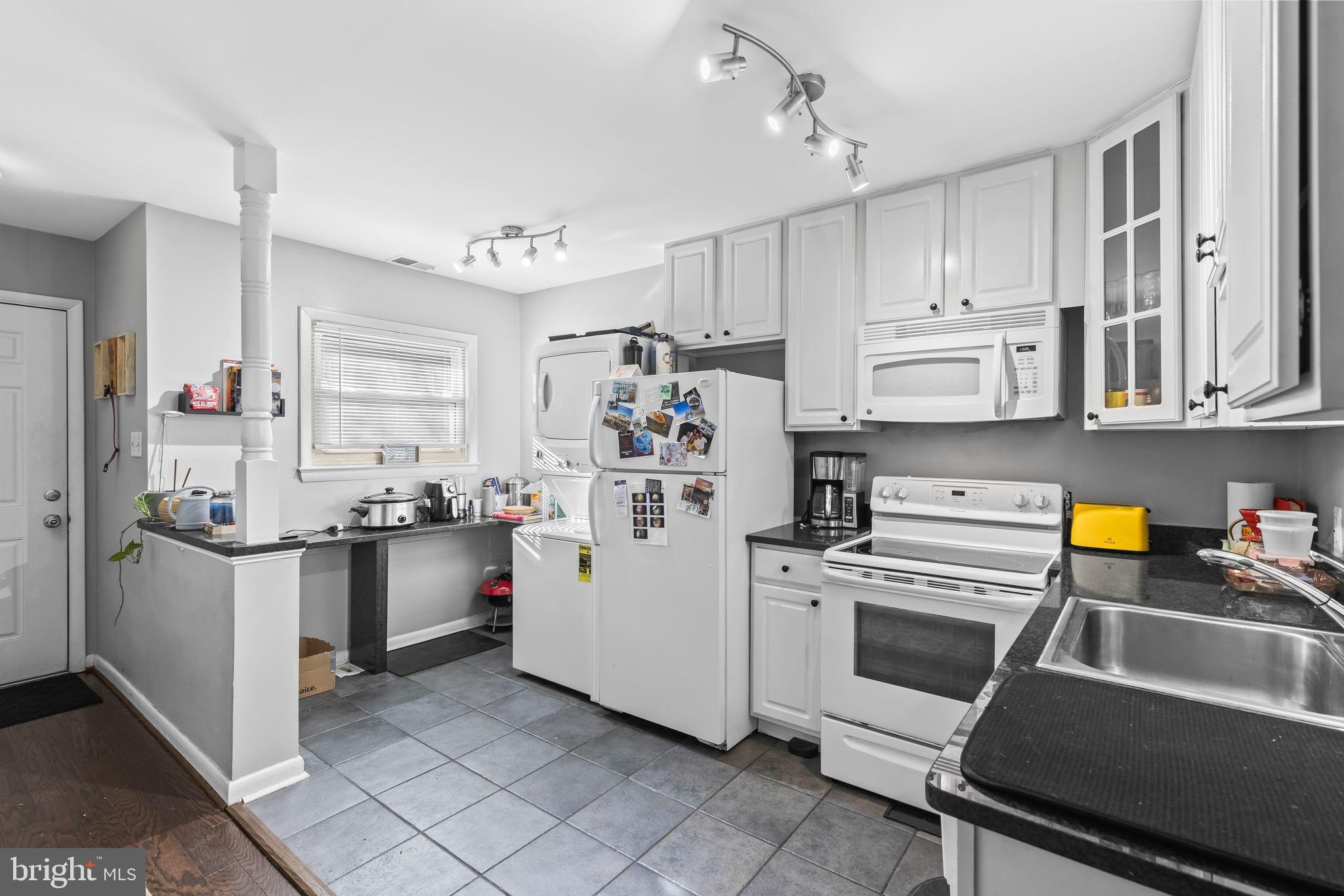 1729 Newton Street Northwest Washington, DC 20010 - Photo 34 of 45 a kitchen with a stove and white cabinets