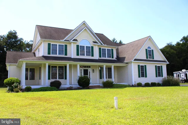 a front view of a house with yard and green space