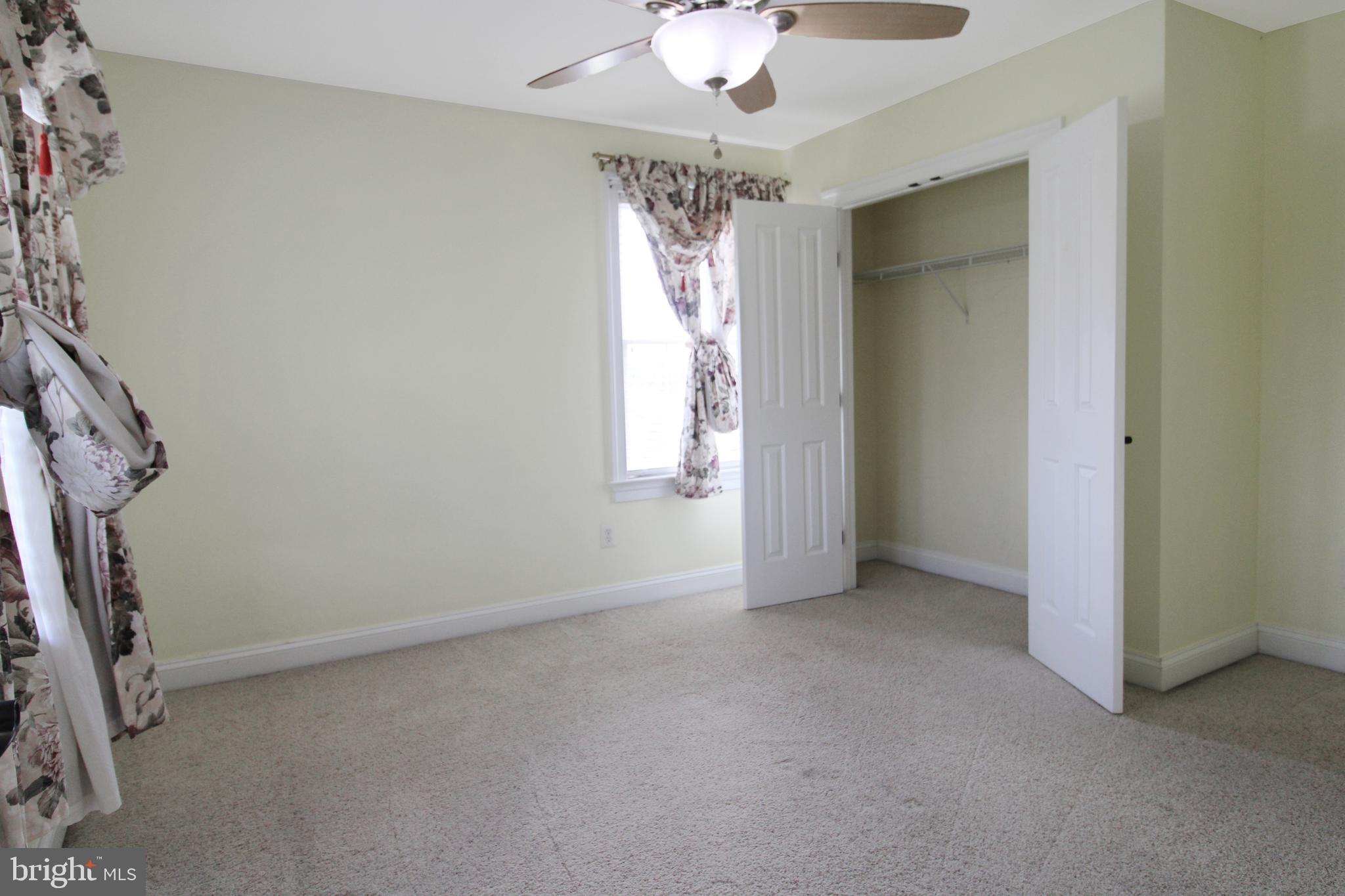 113 Paulowina Road Queen Anne, MD 21657 - Photo 29 of 42 an empty room with windows and chandelier fan