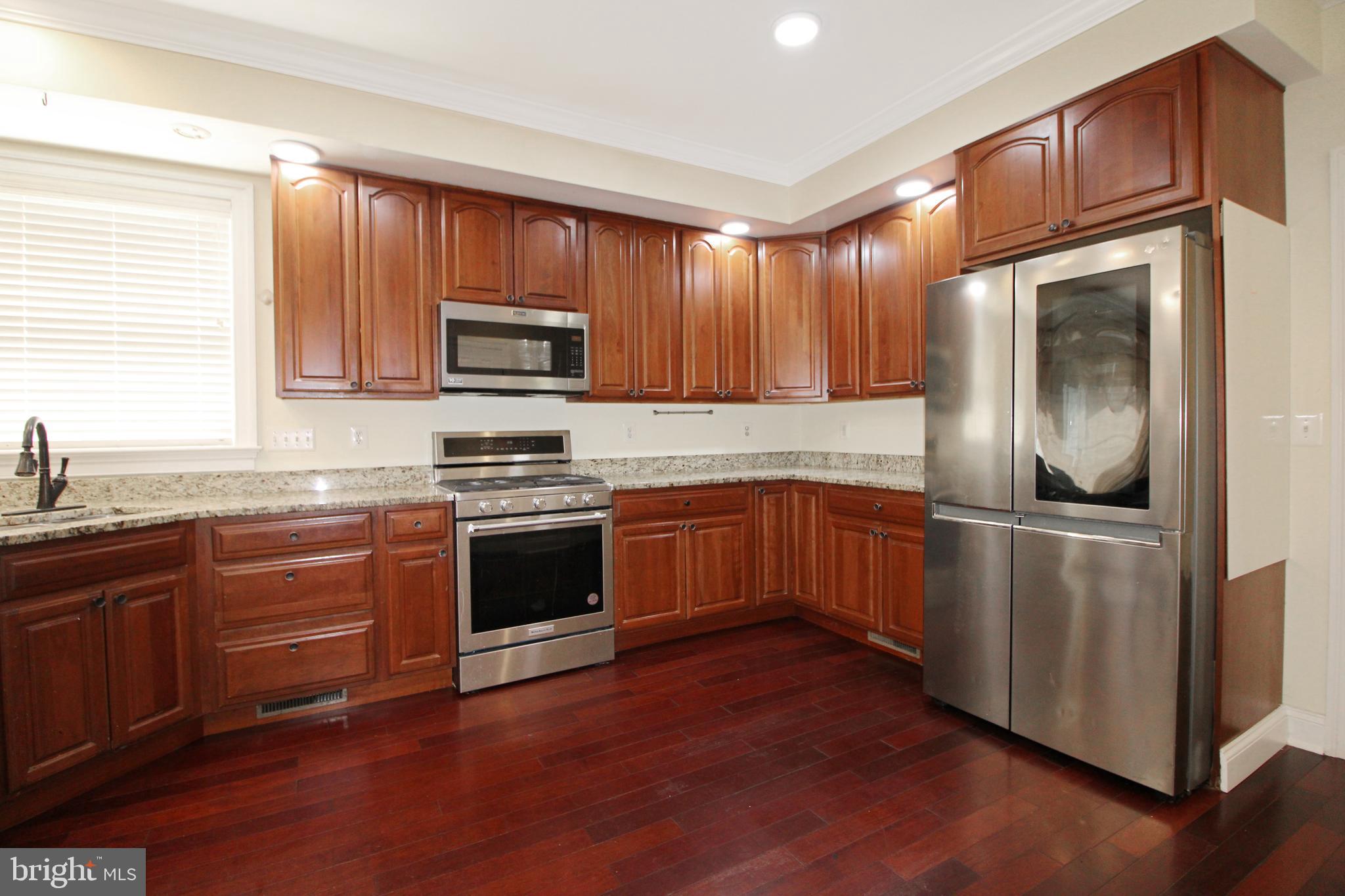 113 Paulowina Road Queen Anne, MD 21657 - Photo 5 of 42 a kitchen with granite countertop wooden cabinets stainless steel appliances and a window
