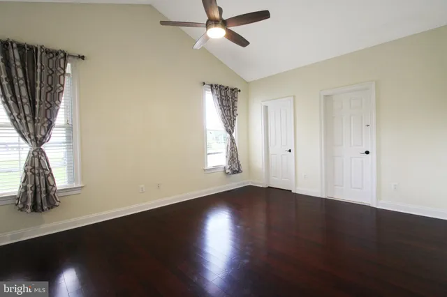 a view of an empty room with a fireplace and a window