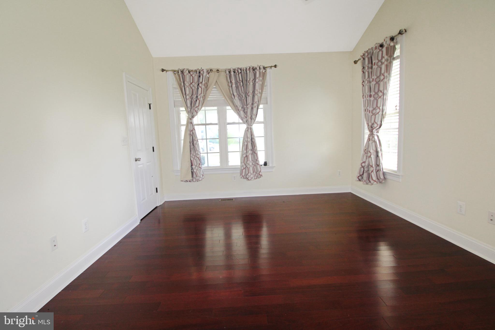 113 Paulowina Road Queen Anne, MD 21657 - Photo 9 of 42 an empty room with wooden floor and windows