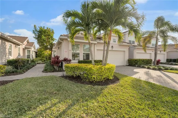 a view of a house with a big yard and potted plants