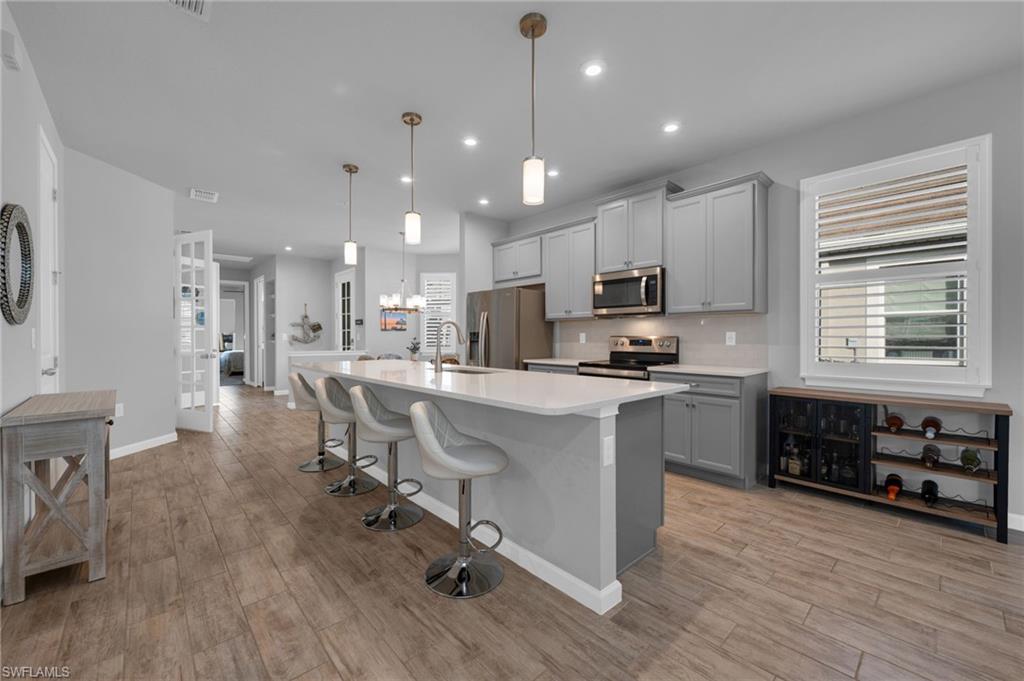 4631 Arboretum Circle, Unit 101 Naples, FL 34112 - Photo 2 of 36 a kitchen with stainless steel appliances kitchen island granite countertop a stove a sink a refrigerator and a microwave