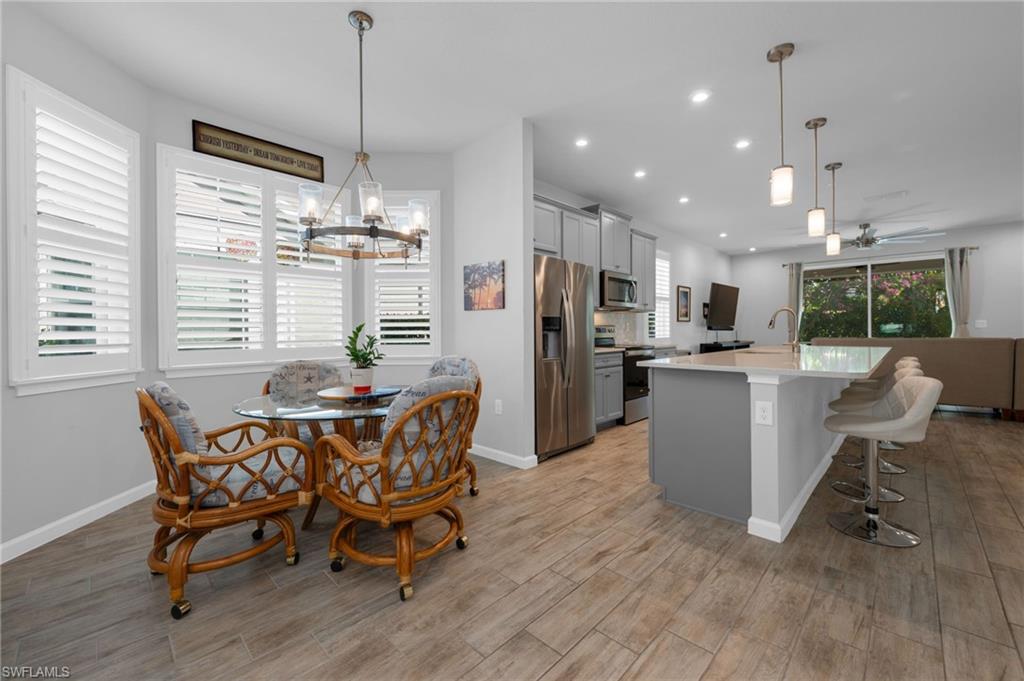 4631 Arboretum Circle, Unit 101 Naples, FL 34112 - Photo 4 of 36 a dining room filled a chandelier furniture and kitchen view