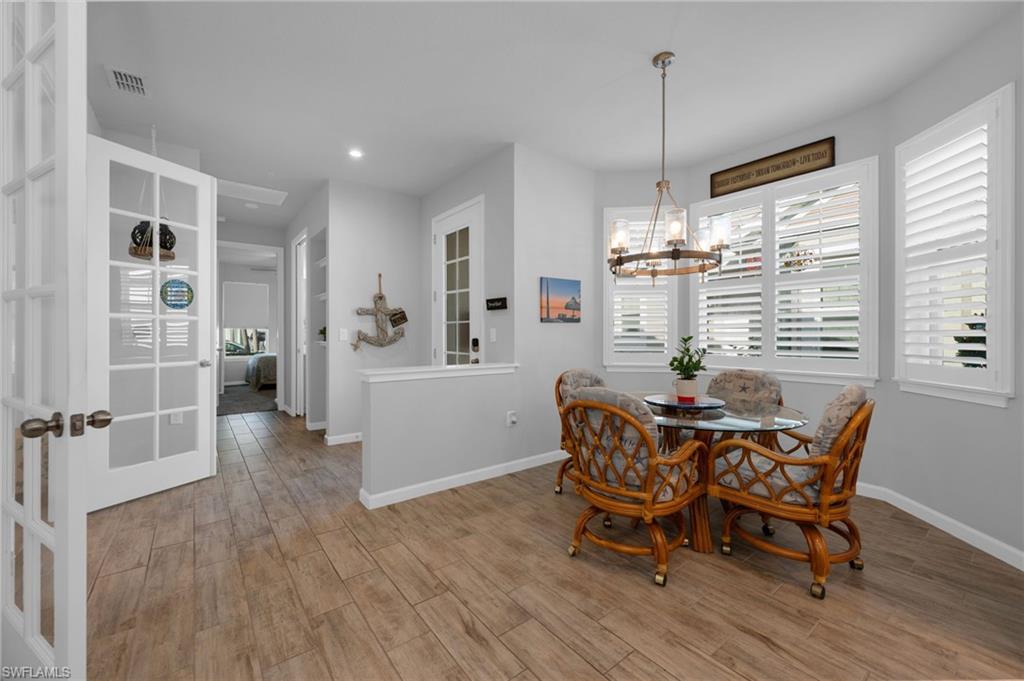 4631 Arboretum Circle, Unit 101 Naples, FL 34112 - Photo 5 of 36 a dining room with furniture and wooden floor