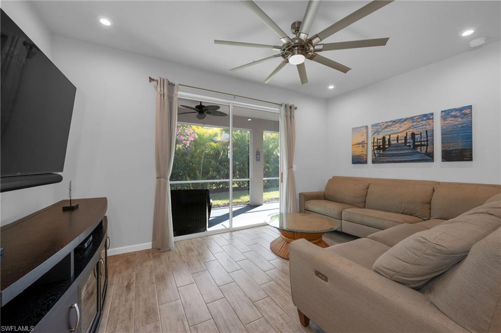 4631 Arboretum Circle, Unit 101 Naples, FL 34112 - Photo 7 of 36 a living room with furniture and a flat screen tv
