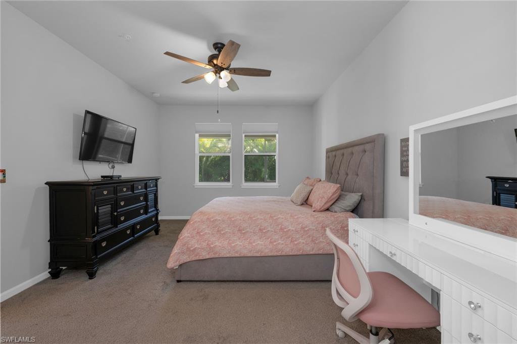 4631 Arboretum Circle, Unit 101 Naples, FL 34112 - Photo 9 of 36 a bedroom with a bed and a flat screen tv