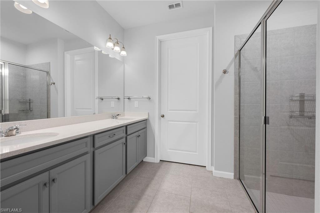 4631 Arboretum Circle, Unit 101 Naples, FL 34112 - Photo 10 of 36 a spacious bathroom with a double vanity sink mirror and shower
