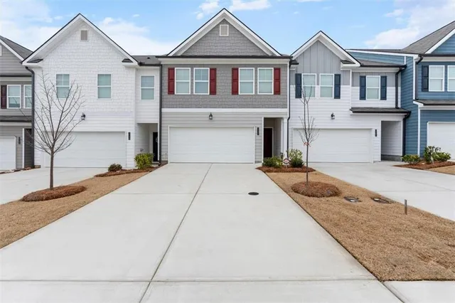 a view of a white house with large windows next to a road