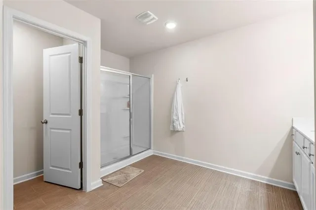 a spacious bathroom with a double vanity sink a mirror and shower
