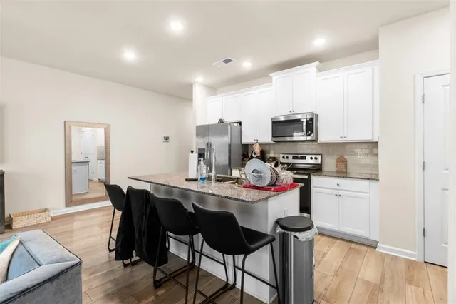 a kitchen with a dining table chairs and refrigerator