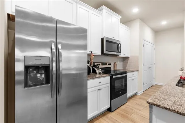 a kitchen with a refrigerator a microwave a stove and cabinets