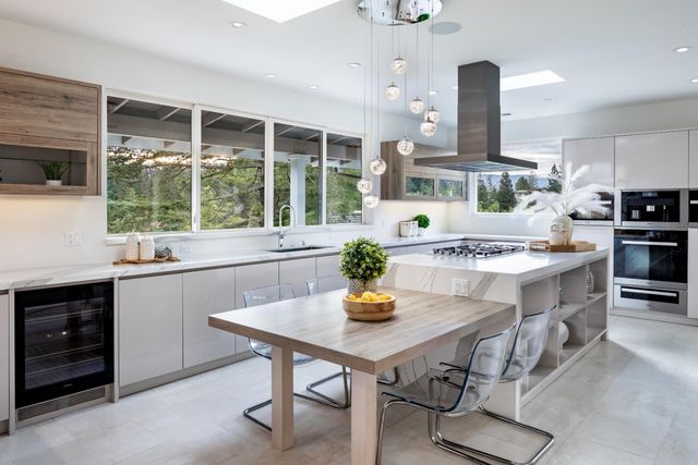 a kitchen with a stove a table and chairs in it
