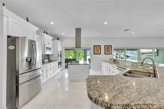 a kitchen with stainless steel appliances granite countertop a refrigerator and a sink